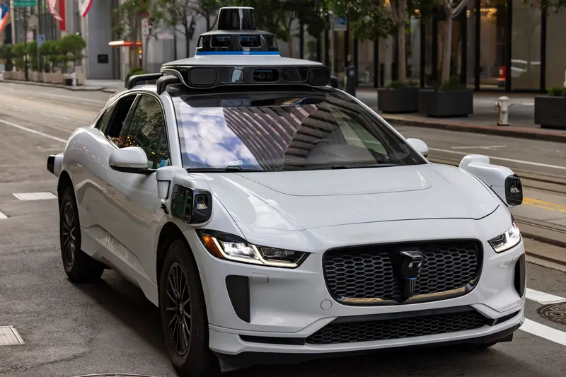 Illustrative photo: sensor-equipped car with a roof-mounted sensor pod on a city street