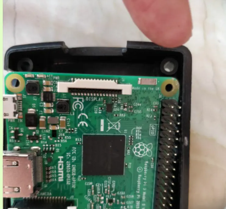 Close-up of a case hole aligned with the Raspberry Pi circuit board mounting hole